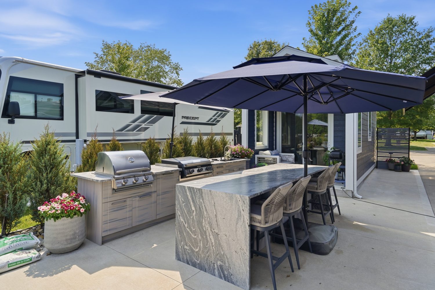 Outdoor kitchen with granite bar seating overlooking the water