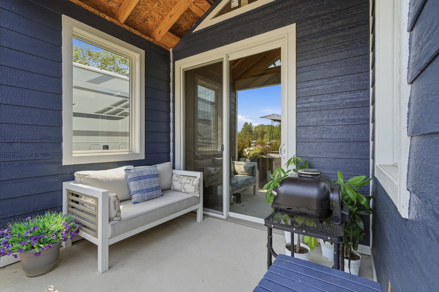 Covered porch of the navy-sided coach house